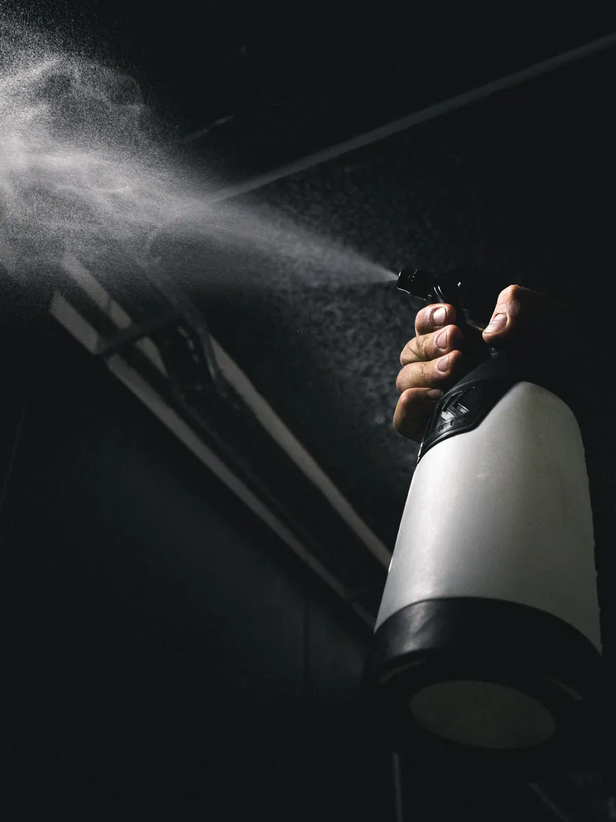 Sprühnebel einer Pumpflasche im Dunkeln